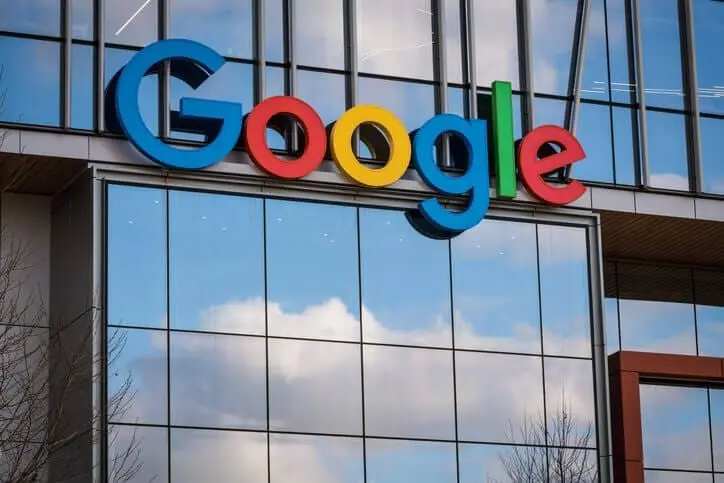 Logotipo colorido do Google na fachada de vidro de um prédio corporativo