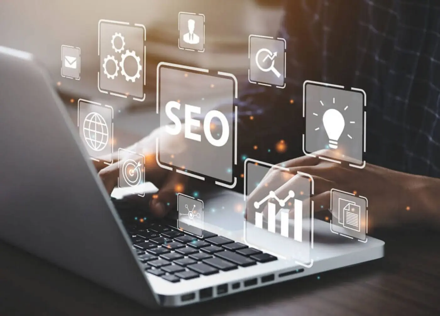 Mãos em notebook com ícones holográficos de SEO, engrenagens, gráfico de crescimento e lâmpada