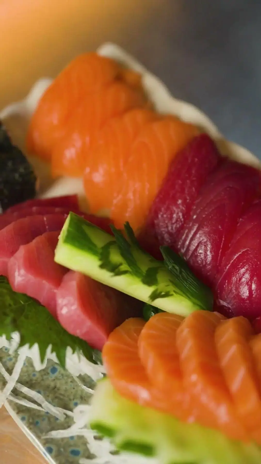 Fatias de sashimi de salmão e atum com pepino em close, em foto de food content para o Grand Hyatt