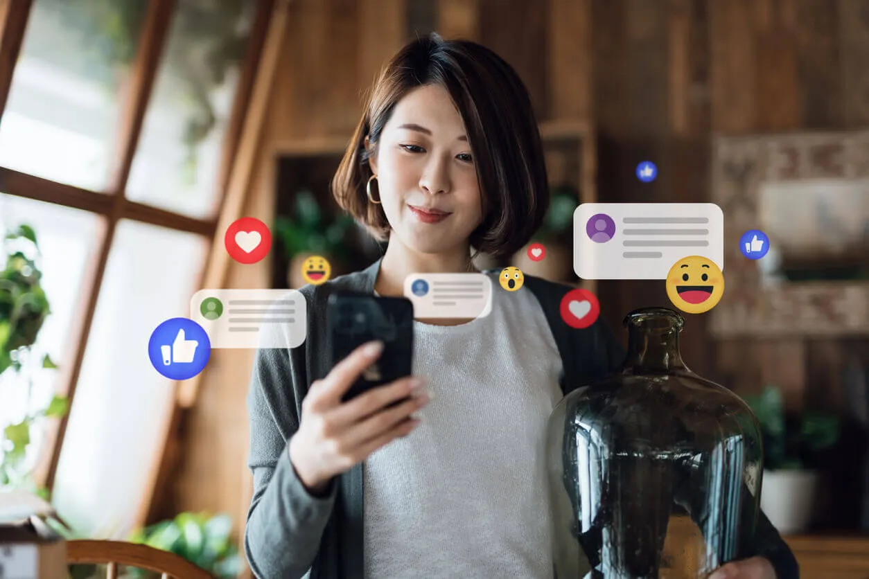 Mulher usando celular e recebendo notificações, curtidas, visualizações e comentários nas redes sociais.