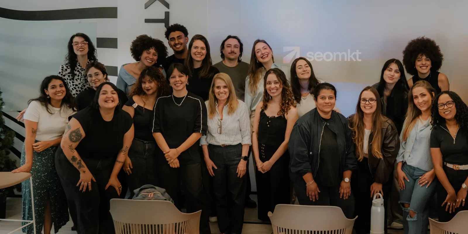 Time da seomkt reunido no SEO Day, em frente ao telão com a marca