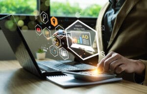 Pessoa trabalhando em um notebook com elementos visuais de Google Ads, marketing digital e redes sociais.