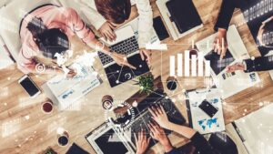 Profissionais em reunião definindo estratégia de marketing digital, com gráficos, computadores e elementos de tecnologia sobrepostos